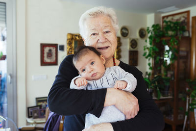 Portrait of smiling great-grandmother holding baby