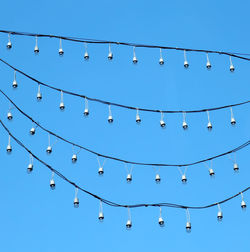 Low angle view of illuminated lights against blue sky