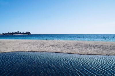 Scenic view of beach against clear blue sky