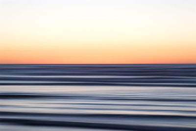 Scenic view of sea against clear sky during sunset