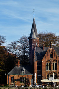 Low angle view of trees and buildings against sky