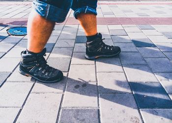 Low section of man standing on tiled floor