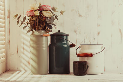 Close-up of flower vase on table against wall