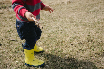 Low section of boy standing on field