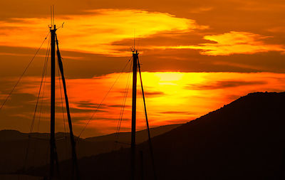 Silhouette of sailboat against orange sky
