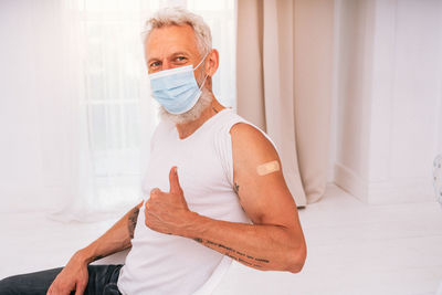 Portrait of man wearing mask at home