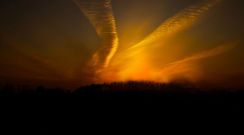 Scenic view of silhouette landscape against orange sky