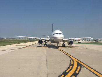 Airplane on runway against clear sky