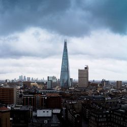 View of cityscape against cloudy sky