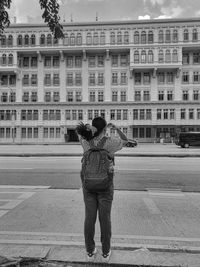 Rear view of woman standing on street in city