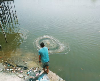 Rear view of man standing in lake