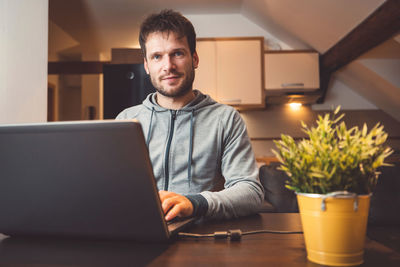 Portrait of man using laptop at home