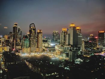 Illuminated cityscape against sky at night