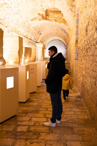 A man looking at ancient sculptures in the museum of the roman circus of tarragona.