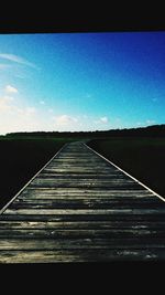 Road leading towards blue sky