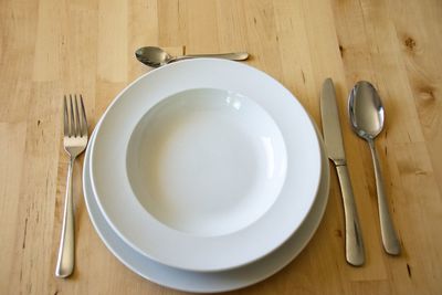 High angle view of eating utensils on wooden table