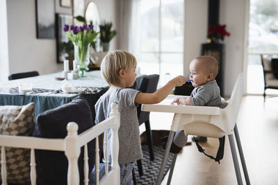 Boy feeding younger sibling