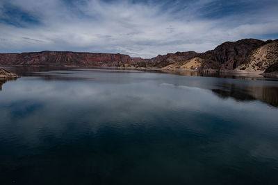 Scenic view of lake by mountains against sky