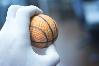 Cropped hand of person holding ball at home