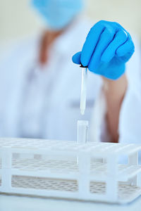 Midsection of scientist examining chemical in laboratory