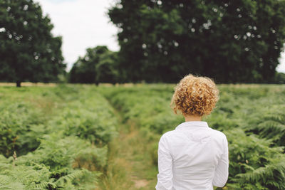 Rear view of young woman on grassy field