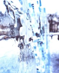 Close-up of icicles against sky during winter