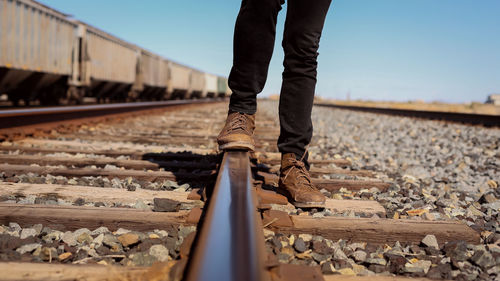 Low section of man standing on railroad track