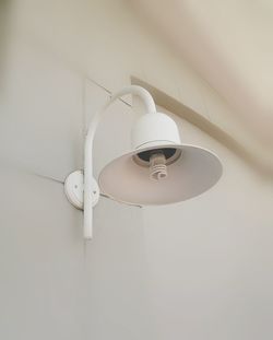 Low angle view of electric lamp hanging at home