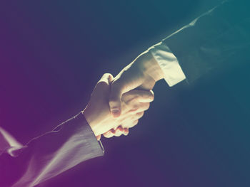 Close-up of hand holding illuminated lighting equipment at night