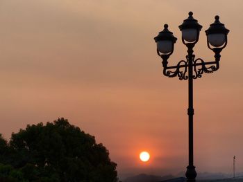 Low angle view of illuminated street light against sky