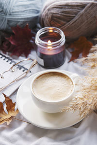 Autumn still life with pumpkins, coffee and burning candles. cozy fall composition