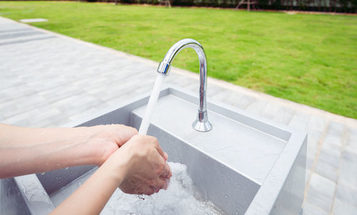 Low section of person washing hands