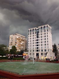 Buildings against cloudy sky