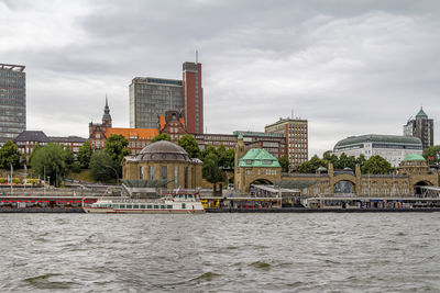 Buildings in city against cloudy sky