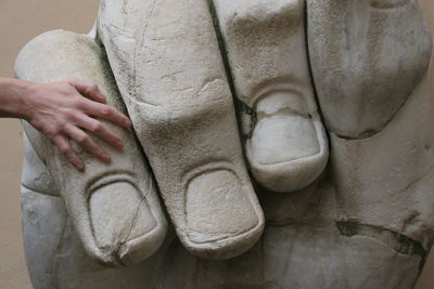 Cropped hand of woman on sculpture