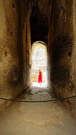 Rear view of woman leaning on wall