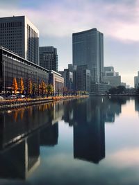 Reflection of buildings in city at sunset