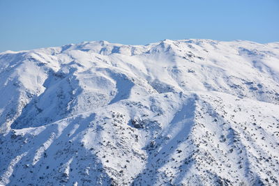 Scenic view of snow mountains against clear blue sky