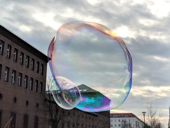 Low angle view of bubbles against rainbow in sky