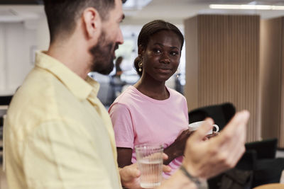 Smiling woman talking with man during break