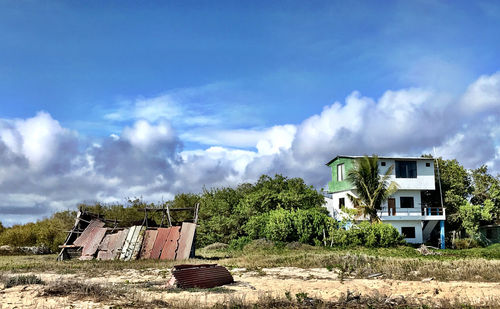 Abandoned house on field against sky