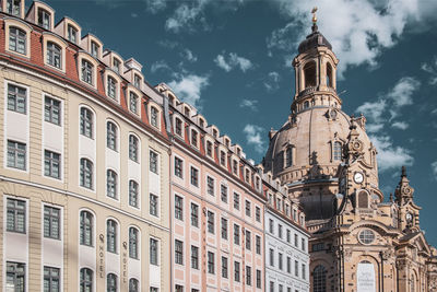 Low angle view of buildings against cloudy sky
