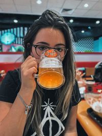 Portrait of a young woman drinking glass