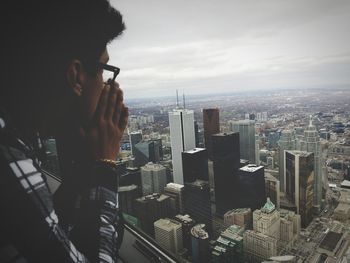 Man photographing cityscape against sky