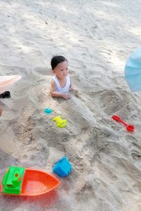 High angle view of girl playing with toy on beach