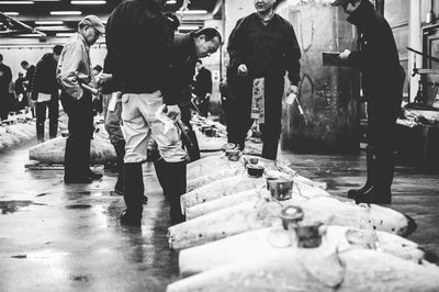 Rear view of people walking on street in rain