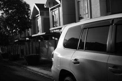 Close-up of car on street against buildings