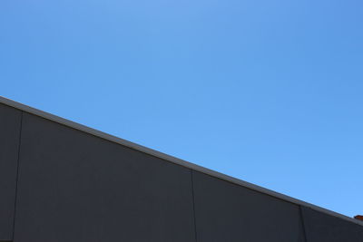 Low angle view of modern building against clear blue sky