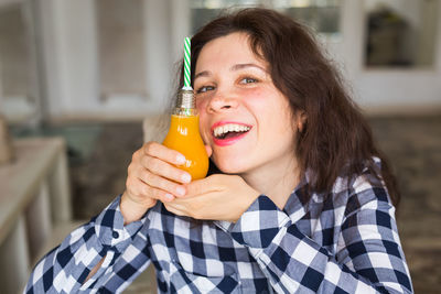 Portrait of smiling woman holding drink