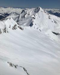 Scenic view of snow covered mountains against sky